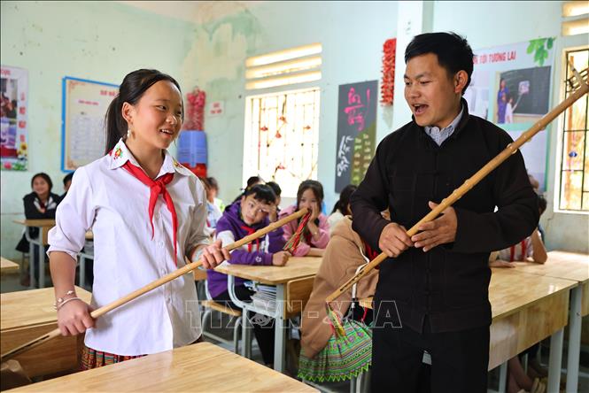 Anh Giàng Seo Lìn dạy múa gậy đồng xu cho học sinh trường Phổ thông dân tộc bán trú và Trung học cơ sở Pà Vầy Sủ, huyện Xín Mần. Ảnh: Minh Đức – TTXVN