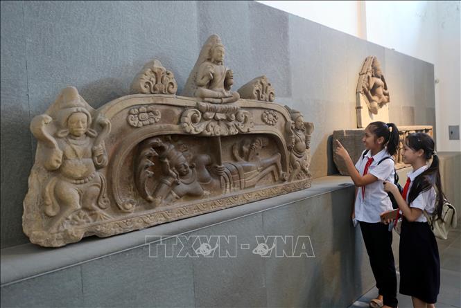 Học sinh Đà Nẵng tìm hiểu về phù điêu Đản sinh Brahma được công nhận Bảo vật quốc gia năm 2024. Ảnh: Trần Lê Lâm - TTXVN 