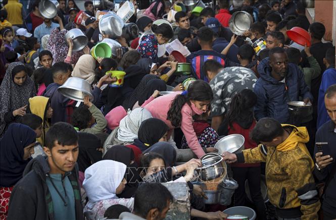 Người dân Palestine nhận thực phẩm viện trợ tại Rafah, miền Nam Dải Gaza ngày 11/3/2024. Ảnh: AFP/TTXVN