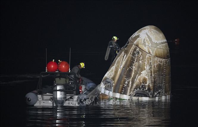 Hình ảnh từ Cơ quan Hàng không Vũ trụ Mỹ (NASA) cho thấy nhóm hỗ trợ làm việc tại hiện trường tàu vũ trụ Crew Dragon của SpaceX đáp xuống vùng biển ngoài khơi thành phố Pensacola, bang Florida, ngày 12/3/2024. Ảnh: AFP/TTXVN