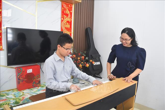 Em Nguyễn Vũ Duy Anh tập đàn tại nhà cùng mẹ. Ảnh: Nguyên Dung – TTTXN