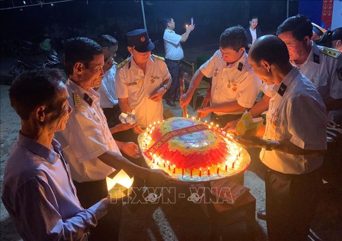Các cựu chiến binh, thân nhân các liệt sĩ Gạc Ma thắp nến, kết vòng hoa tại Lễ tưởng nhớ các liệt sĩ. Ảnh: TTXVN phát