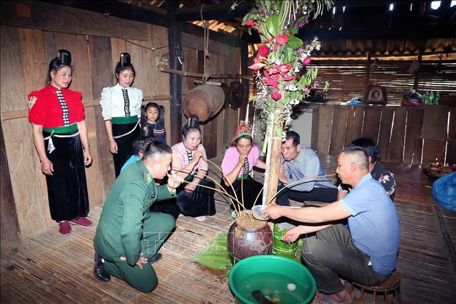 Chủ nhà mời khách mời uống rượu cần sau khi thực hiện xong nghi lễ. Ảnh: Quang Quyết - TTXVN