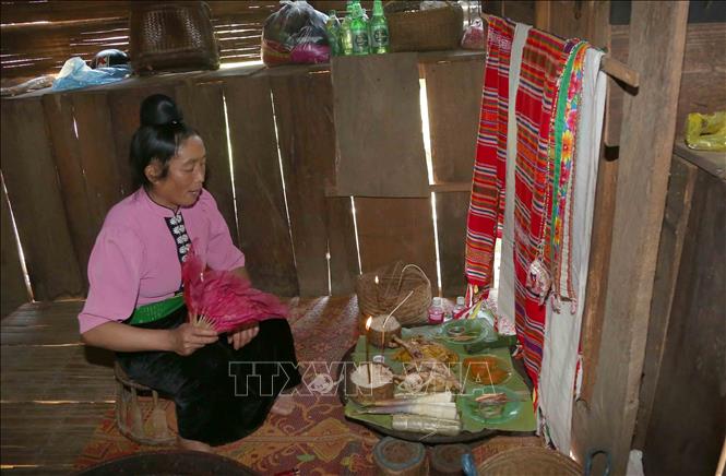 Thực hiện nghi lễ mời các vị thần linh thổ địa, linh hồn tổ tiên về dự và nhận các lễ vật của gia chủ. Ảnh: Quang Quyết - TTXVN