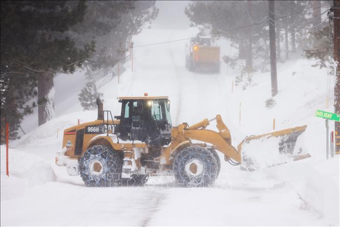 (Tư liệu) Người dân dọn tuyết trên đường tại Mammoth Lakes, California, Mỹ, ngày 2/3/2024. Ảnh: AFP/TTXVN