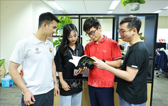Chuyên gia bảo mật Viettel Nguyễn Tuấn Anh trao đổi công việc cùng các đồng nghiệp tại Công ty An ninh mạng Viettel. Ảnh: Minh Đức - TTXVN

