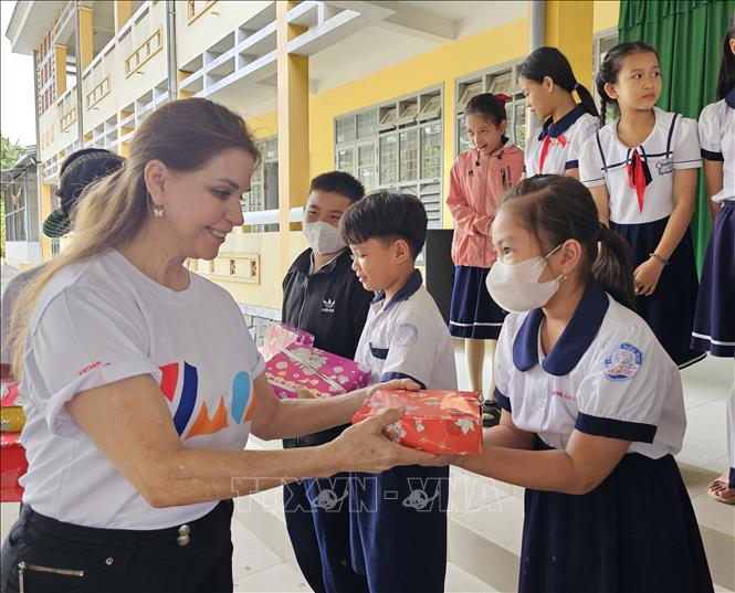 Các tình nguyện viên tổ chức YMCA of Greater Houston (Hoa Kỳ) trao tặng quà cho các em học sinh Trường Tiểu học Tân Phú Tây. Ảnh: Chương Đài - TTXVN