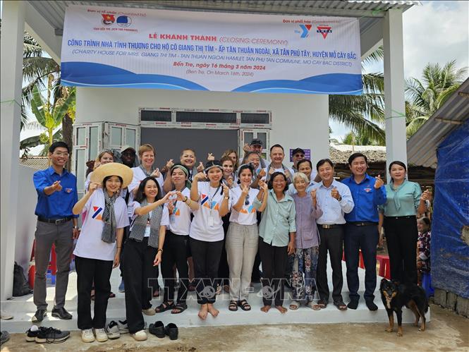 Các tình nguyện viên tổ chức YMCA of Greater Houston (Hoa Kỳ) bàn giao nhà tình thương cho bà Giang Thị Tím ngụ xã Tân Phú Tây, huyện Mỏ Cày Bắc, tỉnh Bến Tre. Ảnh: Chương Đài - TTXVN
