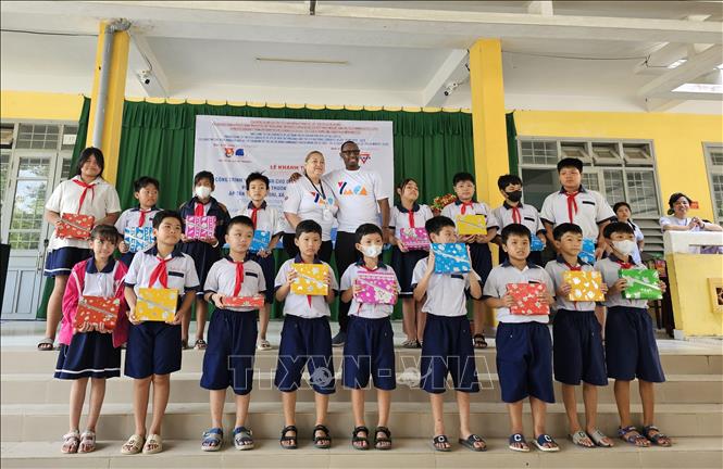 Các tình nguyện viên tổ chức YMCA of Greater Houston (Hoa Kỳ) trao tặng quà cho các em học sinh Trường Tiểu học Tân Phú Tây. Ảnh: Chương Đài - TTXVN