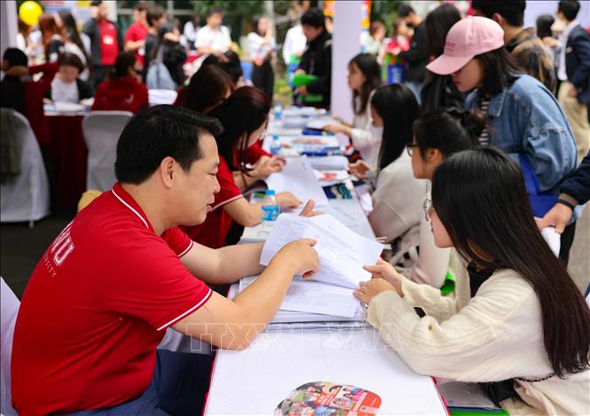 Cán bộ tư vấn của trường đại học Hà Nội giới thiệu về thông tin tuyển sinh của trường, giải đáp thắc mắc của học sinh trong ngày hội. Ảnh: Thanh Tùng - TTXVN