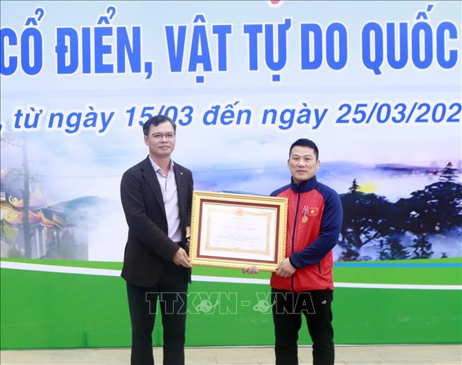 HLV Trần Văn Sơn nhận Huân chương lao động Hạng 3 của Chủ tịch nước tại lễ khai mạc giải. Ảnh: Hoàng Hùng- TTXVN