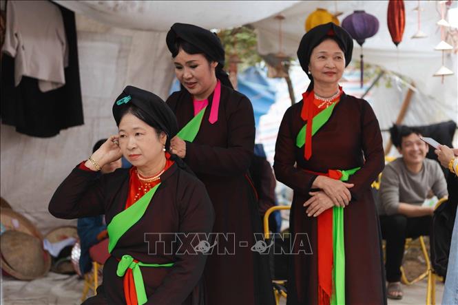 Du khách trải nghiệm trang phục Quan họ. Ảnh: Đoàn Công Vũ - TTXVN phát