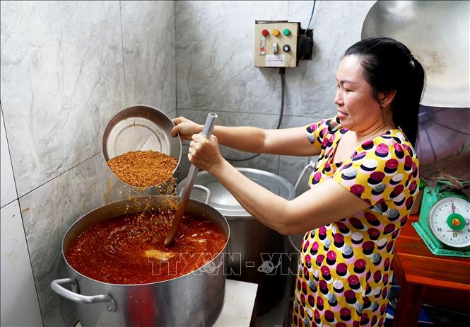 Shop's owner Pham Thi Kim Xuan with a special three-generation recipe prepares her satay soup. VNA Photo: Hồng Đạt