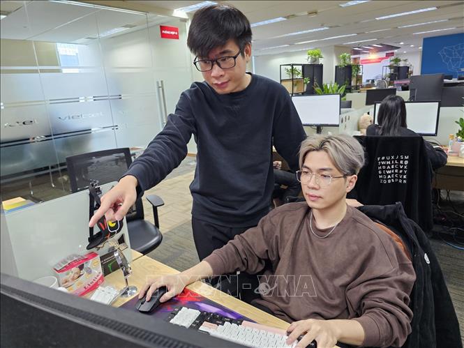 Nguyễn Tuấn Anh (bên trái), hướng dẫn sinh viên thực tập tại Công ty An ninh mạng Viettel. Ảnh: TTXVN phát 