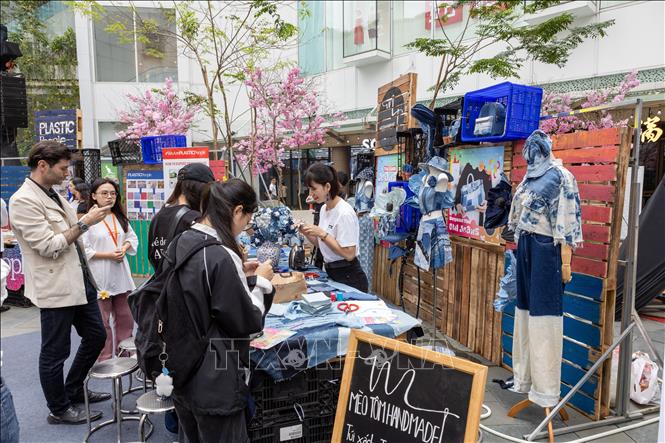 Du khách tham gia trải nghiệm làm những sản phẩm tái chế. Ảnh: Trần Đức Minh – TTXVN phát