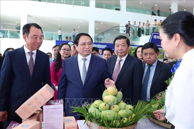 Prime Minister Pham Minh Chinh views a space displaying the province's local faming products. VNA Photo: Dương Giang