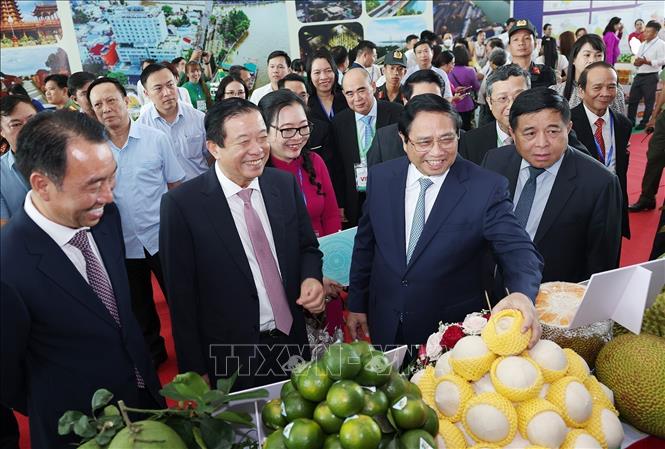 Prime Minister Pham Minh Chinh views a space displaying the province's local faming products. VNA Photo: Dương Giang