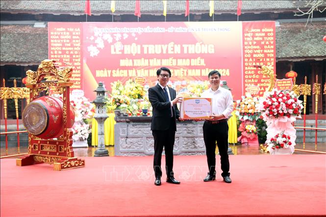 Giám đốc Sở Thông tin và Truyền thông Hải Dương Nguyễn Cao Thắng (bên trái) tặng hệ thống phần mềm quản lý thẻ học sinh thông minh cho Trường THCS Cẩm Điền, huyện Cẩm Giàng. Ảnh: Mạnh Tú - TTXVN