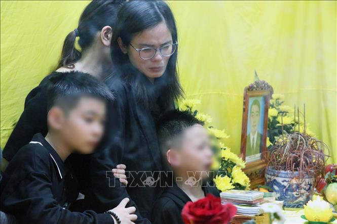 Chị Lê Miền (vợ đại phó Đặng Duy Kiên) cùng hai con trai bên thi hài chồng. Ảnh: Hoàng Ngọc - TTXVN
