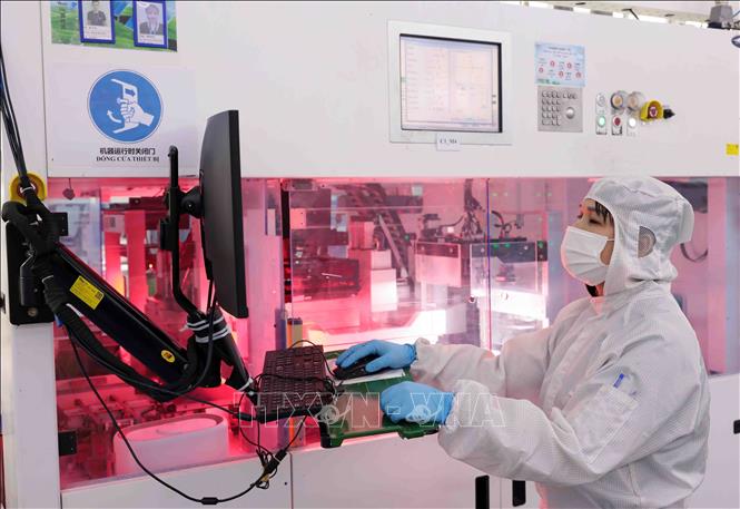 Công nhân điều khiển máy sản xuất tấm mô-đun năng lượng mặt trời tại nhà máy. Ảnh: Trần Việt - TTXVN
