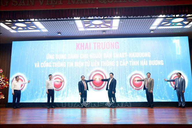 Các đại biểu bấm nút khai trương ứng dụng dành cho người dân (App Smart-Hai Duong) và Cổng Thông tin điện tử liên thông 3 cấp của tỉnh. Ảnh: Mạnh Tú - TTXVN