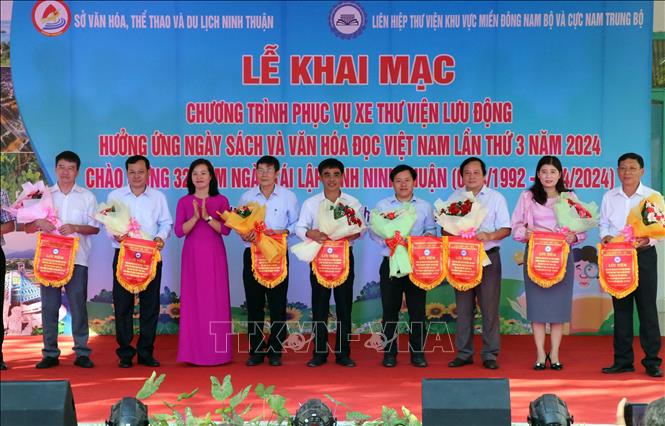 Lãnh đạo Sở Văn hóa, Thể thao và Du lịch tỉnh Ninh Thuận tặng hoa chúc mừng Liên hiệp Thư viện khu vực miền Đông Nam bộ và cực Nam Trung bộ đã mang sách đến phục vụ nhu cầu đọc tại tỉnh. Ảnh: Công Thử - TTXVN