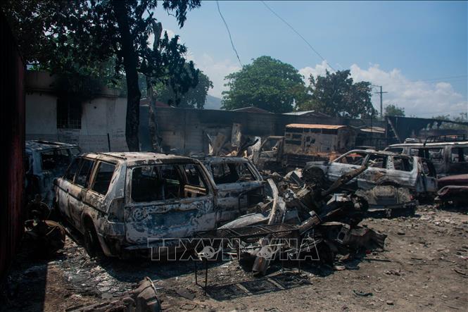 Các phương tiện bị đốt cháy trong bạo lực băng nhóm ở thủ đô Port-au-Prince, Haiti, ngày 25/3/2024. Ảnh: AFP/TTXVN