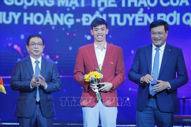 Phó Tổng giám đốc TTXVN Nguyễn Tuấn Hùng và ông Đặng Hà Việt, Cục trưởng Cục Thể dục Thể thao trao giải thưởng Thể thao, hạng mục “Gương mặt thể thao của năm” cho kình ngư Nguyễn Huy Hoàng. Ảnh: Minh Quyết - TTXVN