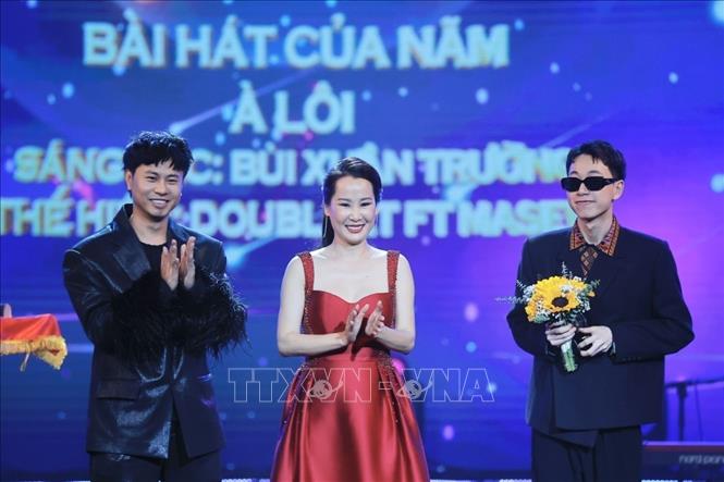 Nhạc sĩ Giáng Son (giữa) và nhạc sĩ Dương Cầm trao giải Âm nhạc, hạng mục “Bài hát của năm” cho nghệ sĩ Double2T (phải) với bài hát “À Lôi”. Ảnh: Minh Quyết - TTXVN