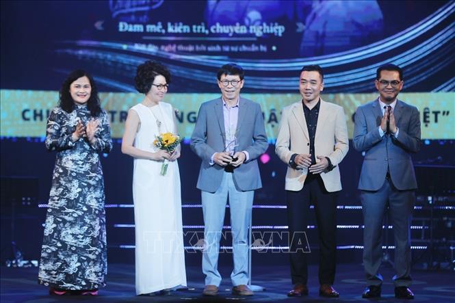 Phó Tổng giám đốc TTXVN Nguyễn Thị Sự và NSND Trung Hiếu trao giải thưởng hạng mục “Ấn tượng cống hiến” cho Êkip sản xuất chương trình nghệ thuật “Đàn chim Việt” kỷ niệm 100 năm Ngày sinh nhạc sĩ Văn Cao. Ảnh: Minh Quyết - TTXVN