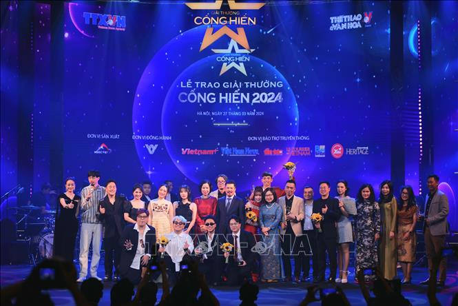 Ban lãnh đạo TTXVN cùng các đại biểu và các nghệ sĩ nhận Giải thưởng Cống hiến. Ảnh: Hoàng Hiếu - TTXVN