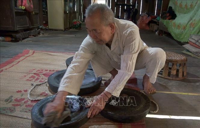 Già làng Van Văn Hoàn gìn giữ bộ chiêng có tuổi đời từ 50 năm tuổi. Ảnh: TTXVN phát