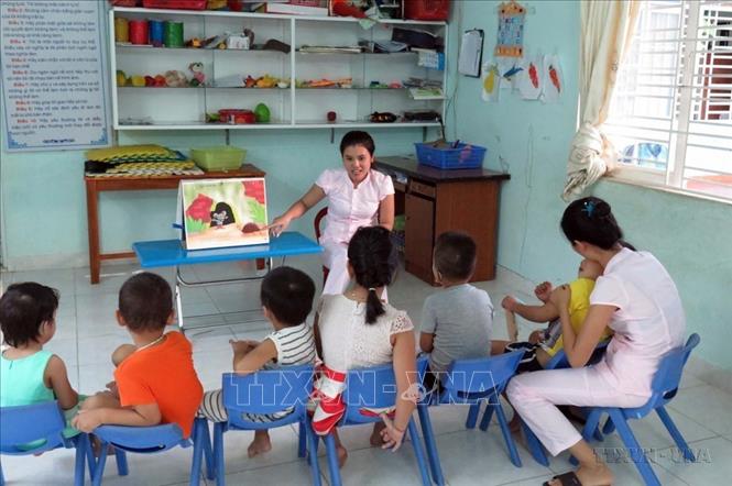 Giáo viên Cơ sở bảo trợ xã hội Thiện Nhân ở phường Hòa Thuận, thành phố Tam Kỳ (Quảng Nam) hướng dẫn trẻ tự kỷ nhận diện hình ảnh (2016). Ảnh: Đỗ Trưởng - TTXVN