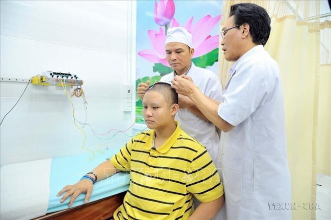 Bác sỹ Bệnh viện Châm cứu Trung ương thực hiện điện châm điều trị bệnh cho trẻ tự kỷ tại Viện Y dược học dân tộc Thành phố Hồ Chí Minh (2019). Ảnh: Đinh Hằng - TTXVN