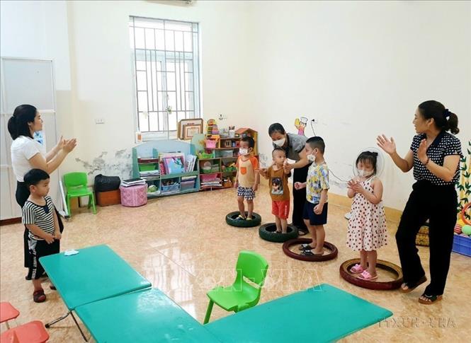 Giáo viên tại Quỹ bảo trợ trẻ em tỉnh Nghệ An can thiệp, trị liệu giúp trẻ tự kỷ làm quen với các bài vận động đơn giản (2022). Ảnh: Tá Chuyên - TTXVN
