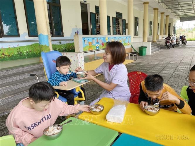 Các cô giáo tại Làng trẻ em mồ côi Hà Tĩnh chăm sóc trẻ bị khuyết tật, tự kỷ, chậm phát triển trong giờ ăn trưa. Ảnh: Hữu Quyết - TTXVN