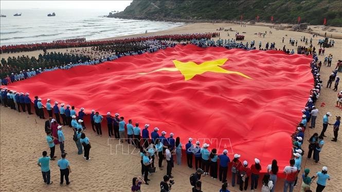 Lá cờ Tổ quốc rộng hơn 1.000m2 được trải dài tại Bãi Môn. Ảnh: TTXVN phát
