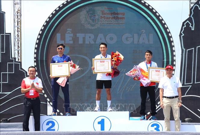 Trao giải Nhất, Nhì, Ba cho các vận động viên tranh tài nội dung full marathon (42,195km) hệ nam tuyển. Ảnh: Tường Quân – TTXVN