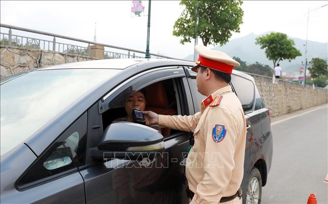 A traffic police officer conducts a breathalyser test on a driver in the northern province of Lao Cai. VNA Photo: Quốc Khánh