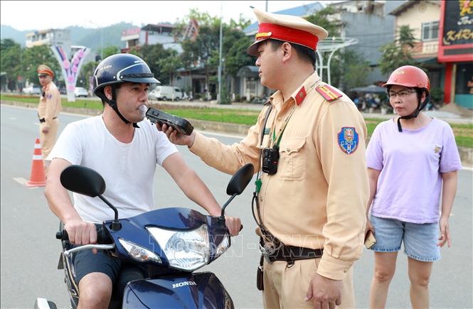 A traffic police officer conducts a breathalyser test on a driver in the northern province of Lao Cai. VNA Photo: Quốc Khánh