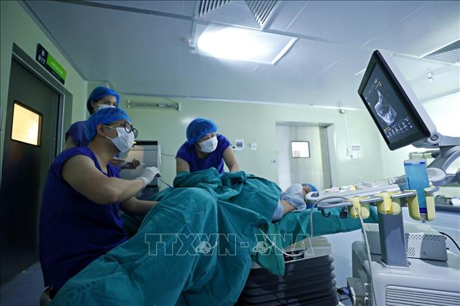 Bác sĩ lâm sàng tiến hành chuyển phôi vào buồng tử cung cho bệnh nhân. Ảnh: Minh Quyết – TTXVN