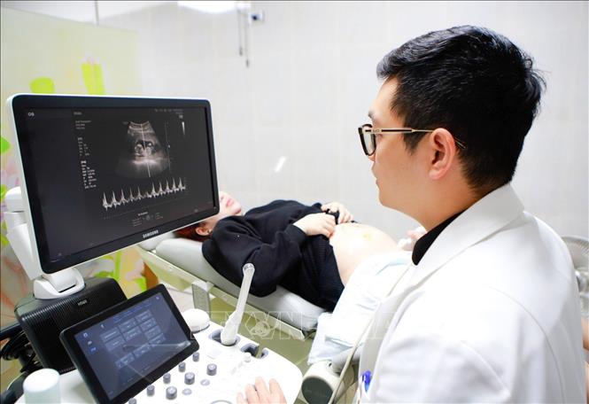 Bác sĩ Khoa Hỗ trợ sinh sản (Bệnh viện Phụ sản Hà Nội) siêu âm cho bệnh nhân thai đôi 13 tuần được thực hiện bằng phương pháp thụ tinh ống nghiệm IVF. Ảnh: Minh Quyết – TTXVN