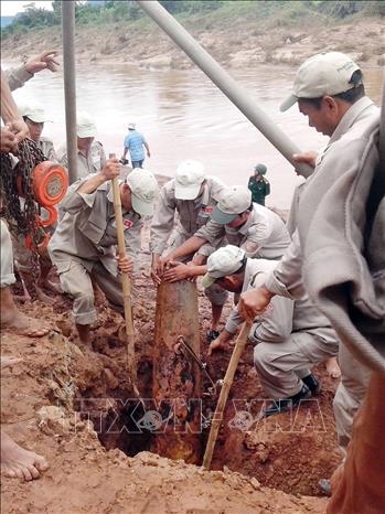 Đội rà phá bom, mìn lưu động tỉnh Quảng Trị tiến hành di chuyển quả bom phát hiện trong mùa mưa lũ năm 2013 tại thôn A Ho, xã Thanh, huyện Hướng Hóa. Ảnh: Hồ Cầu-TTXVN