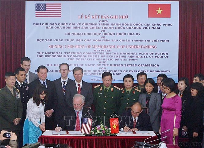 Ký kết Bản ghi nhớ giữa Ban Chỉ đạo Quốc gia về Chương trình hành động quốc gia khắc phục hậu quả bom, mìn sau chiến tranh của Việt Nam và Bộ Ngoại giao Hoa Kỳ về hợp tác khắc phục hậu quả bom, mìn sau chiến tranh tại Việt Nam (2013). Ảnh: Trọng Đức - TTXVN
