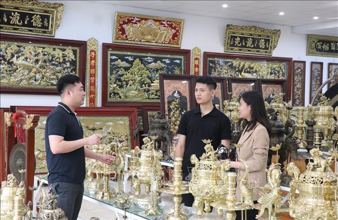 Anh Hoàng Văn Quân giới thiệu các sản phẩm làng nghề. Ảnh: Thanh Thương - TTXVN