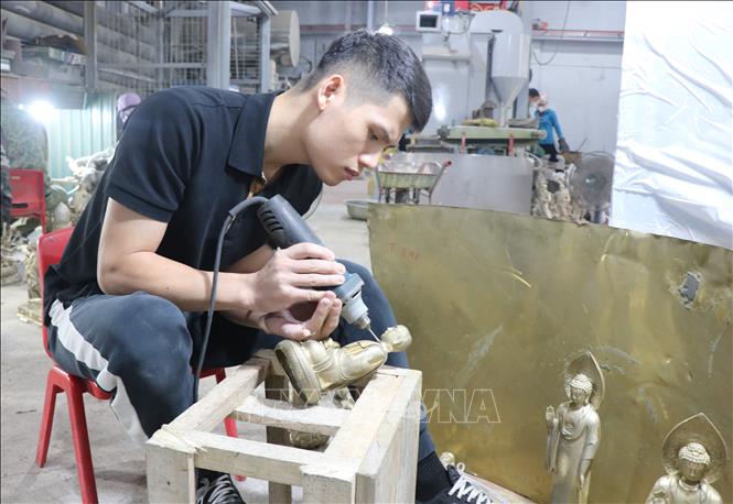 Anh Hoàng Văn Quân tỉ mỉ tạo tạo hình các pho tượng. Ảnh: Thanh Thương - TTXVN