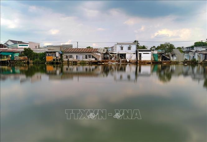 Những căn nhà bị sạt lở trên sông Trà Nóc ngày 3/4 nhìn từ phía phường Trà Nóc. Ảnh: Thanh Liêm - TTXVN 