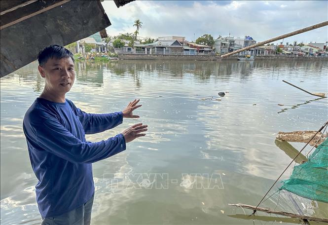 Ồng Trần Văn Mừng, khu vực 2, phường Trà An, quận Bình Thủy, TP Cần Thơ chỉ về vị trí căn nhà sau của ông đã bị chìm xuống sông Trà Nóc. Ảnh: Thanh Liêm - TTXVN