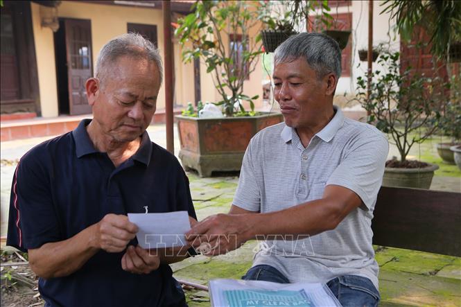 Cán bộ xã Mỹ Tân, huyện Mỹ Lộc, trao Giấy chứng nhận tiêm phòng bệnh dại cho người dân sau khi tiêm đã tiêm vaccine phòng bệnh dại. Ảnh: Công Luật-TTXVN