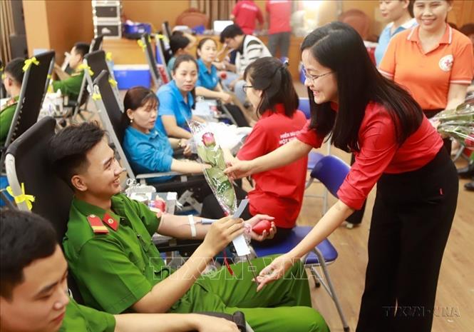 Phó Chủ tịch Hội Chữ thập đỏ tỉnh Vĩnh Phúc Nguyễn Thị Quỳnh Liên tặng hoa chúc mừng người hiến máu tình nguyện tại Ngày hội hiến máu tình nguyện “Những trái tim Hồng”. Ảnh: Hoàng Hùng - TTXVN